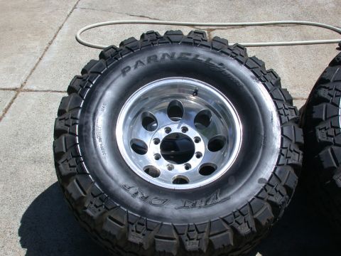 1996 Ford Bronco - Close-up of off-road tires and rims, with one tire prominently displayed and another partially visible to the right.