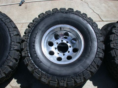 1996 Ford Bronco - Set of off-road tires and rims, likely for a truck or SUV, displayed outdoors.