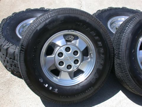 1996 Ford Bronco - Four tires and rims are shown, with one tire white lettering. The rims have a Chevrolet logo.