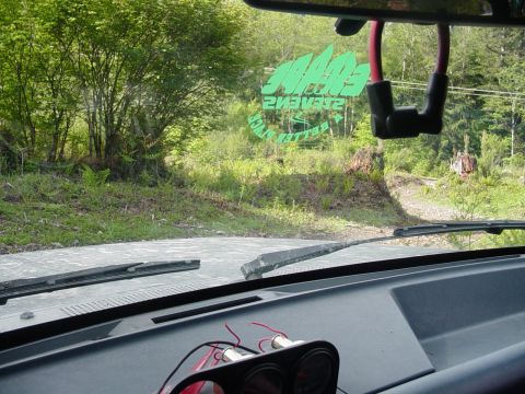 1987 Ford Bronco - View from inside a vehicle, showing the dashboard and a green sticker on the windshield.