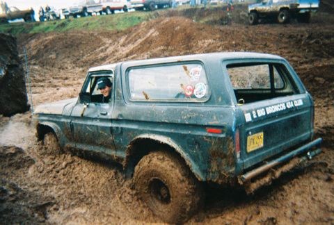 1978 Ford Bronco - A 1978 Ford Bronco navigates a muddy off-road course, with other vehicles visible in the background.