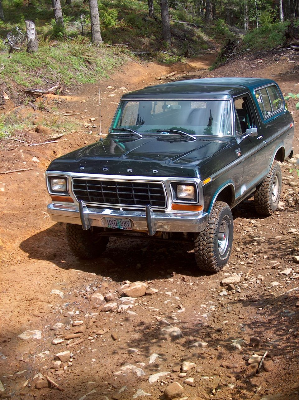 Dark green Ford Bronco on a dirt road