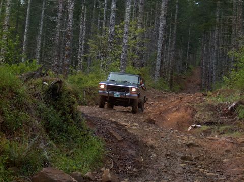 1978 Ford Bronco - A 1978 Ford Bronco navigates a rocky, wooded trail.