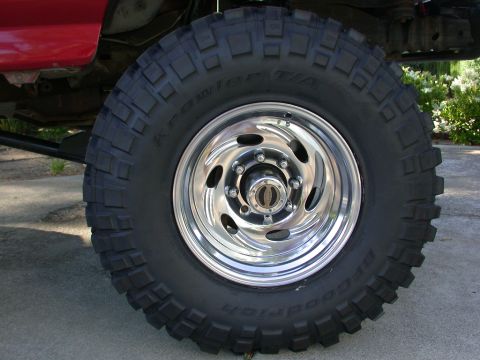 1996 Ford Bronco - Close-up of a chrome wheel and BFGoodrich Krawlers tire on a red vehicle.