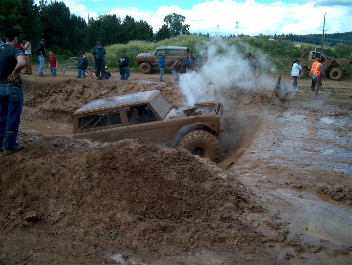 1979 Ford Bronco stuck in mud, steam rising from engine bay