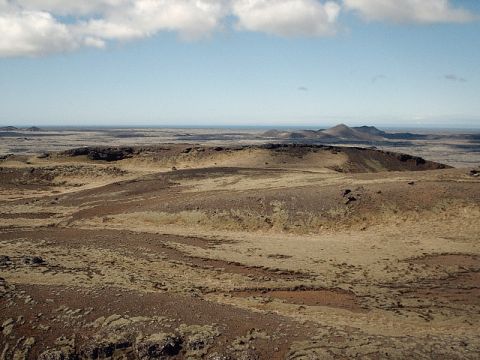 1996 Ford Bronco - Expansive view of a volcanic terrain with hills and a hazy horizon under a partly cloudy sky.