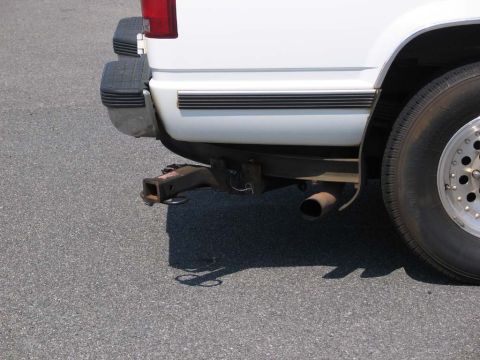 1995 Ford Bronco - Rear view of a white vehicle showing the bumper, trailer hitch, and exhaust pipe.