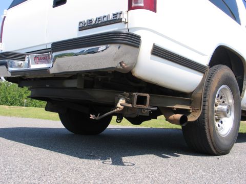 1995 Ford Bronco - The rear of a white Chevrolet pickup truck is shown, a chrome bumper and a trailer hitch assembly.