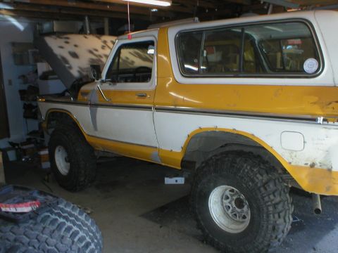 1978 Ford Bronco - This classic Ford Bronco is undergoing some work in a garage, with its hood up and large tires visible.