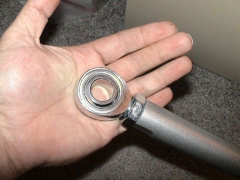1979 Ford Bronco - Close-up of a rod end bearing part held in a hand.