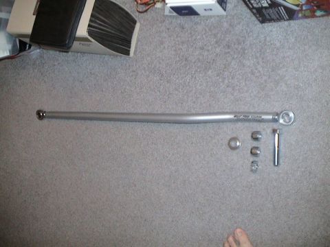 1979 Ford Bronco - A silver adjustable track bar and its associated hardware are laid out on a carpeted surface.