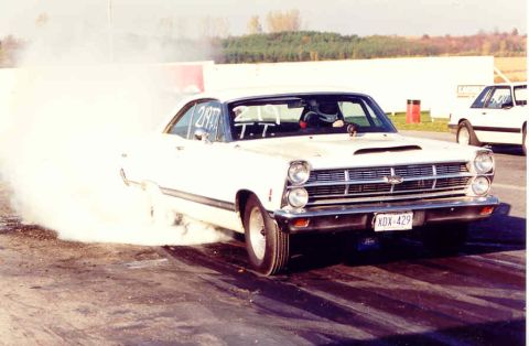 1967 Ford Fairlane - A white 1966 Ford Fairlane performs a burnout, kicking up smoke on the drag strip.