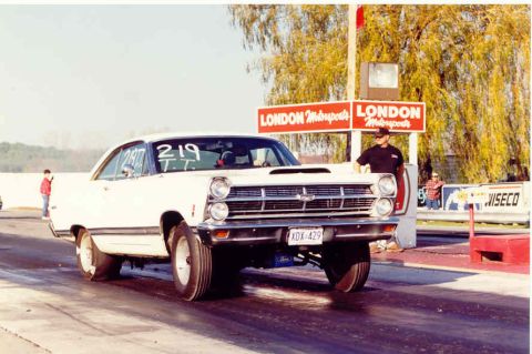 1967 Ford Fairlane - A white 1966 Ford Fairlane drag car is captured in a 3/4 front view at a drag strip.