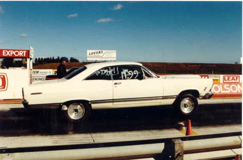 1967 Ford Fairlane - A white coupe is on the drag strip, with "11.99" written on the window.