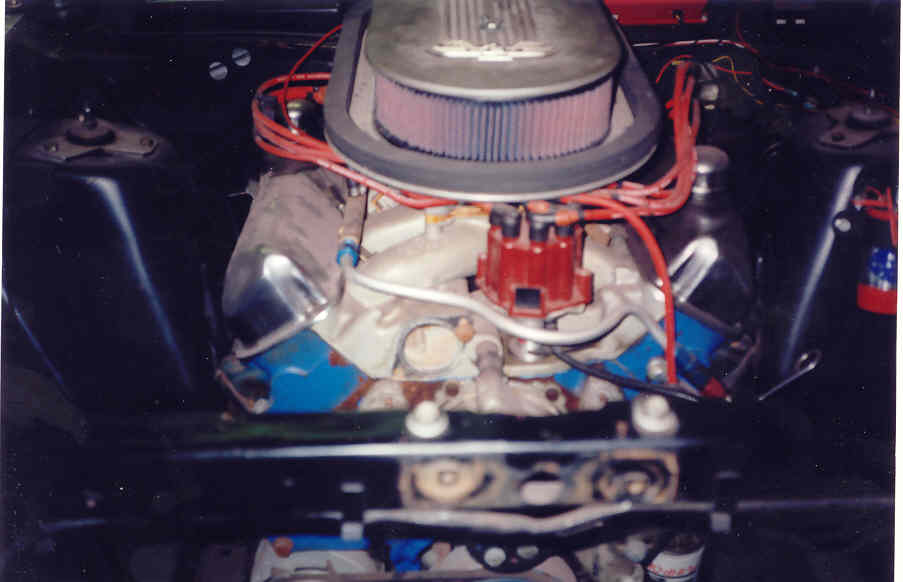Ford V8 engine bay with blue block, aluminum intake, red distributor and oval air cleaner