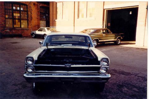 1967 Ford Fairlane - A white 1966 Ford Galaxie is parked with its hood open, with another car visible in the background.