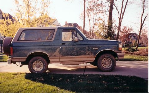 1996 Ford Bronco - This 1996 Ford Bronco is seen from the side, its distinctive two-tone paint and rear-mounted spare tire.
