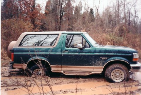 1996 Ford Bronco - This 1996 Ford Bronco is deep in the mud, showing its off-road capabilities.