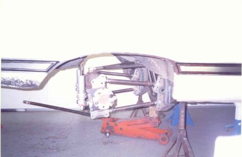 1967 Ford Fairlane - Close-up view of a vehicle's suspension system undergoing maintenance, with various mechanical components visible.