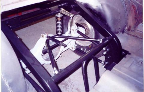 1967 Ford Fairlane - Close-up view of a modified car's rear suspension system, including a shock absorber and roll cage.