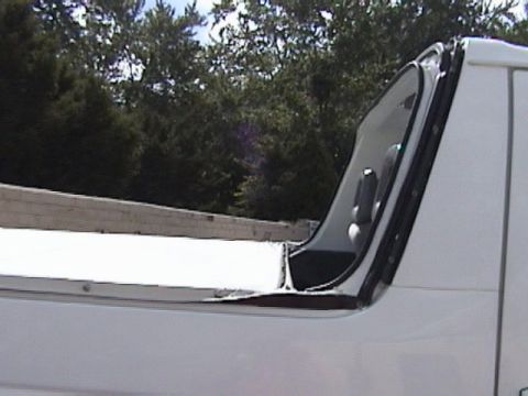 1995 Ford Bronco - Close-up view of the open door and bed of a white pickup truck with a watermark at the bottom right.