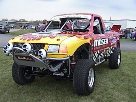 1995 Ford Bronco - This heavily modified truck features a roll cage, custom bumper with lights, and flame decals.