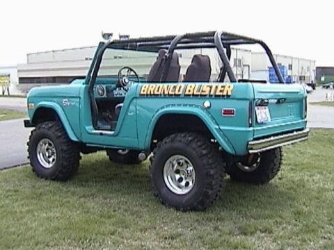 1995 Ford Bronco - This teal Ford Bronco, modified with a roll cage and large tires, displays "Bronco Buster" on its side.