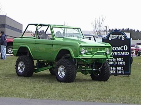 1995 Ford Bronco - Modified first-generation Ford Bronco with off-road tires and roll cage.