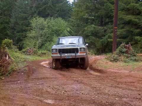 1978 Ford Bronco - The 1978 Ford Bronco navigates a challenging muddy trail, kicking up dirt as it goes.
