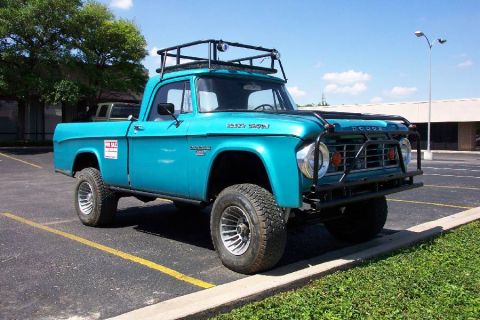 1992 Ford Bronco - This blue 1965 Dodge pickup truck is equipped with a roof rack and brush guard.