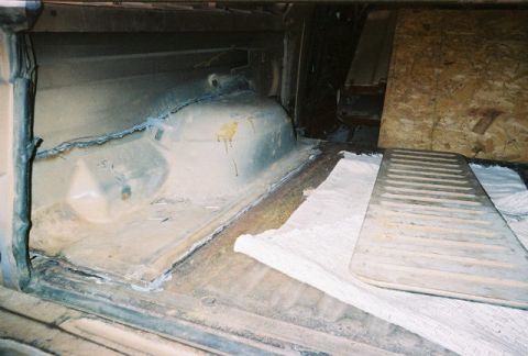 1983 Ford Bronco - The interior cargo area shows a metal floor with a ribbed mat placed on white cloth.