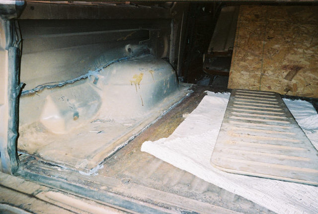 Welded-in replacement cab floor panel with visible weld seams in a stripped truck interior
