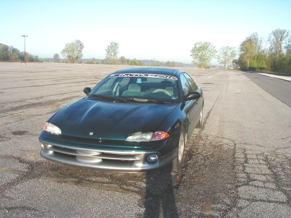 Dark green 1995 Dodge Intrepid parked on cracked asphalt, front 3/4 view