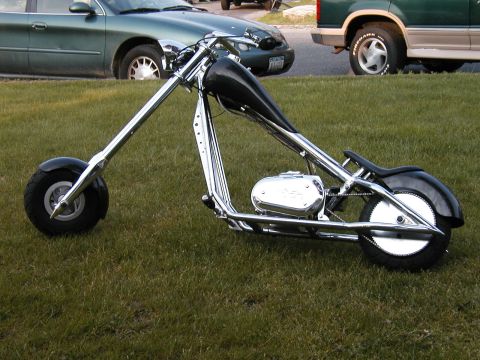1994 Ford Bronco - A custom chopper motorcycle is parked on a grassy area with other vehicles in the background.