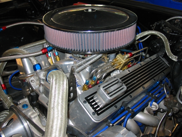 Built V8 engine bay with chrome air cleaner, braided lines and blue plug wires