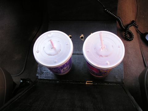 1996 Ford Bronco - Two cups of soda sit in the center console of a vehicle.