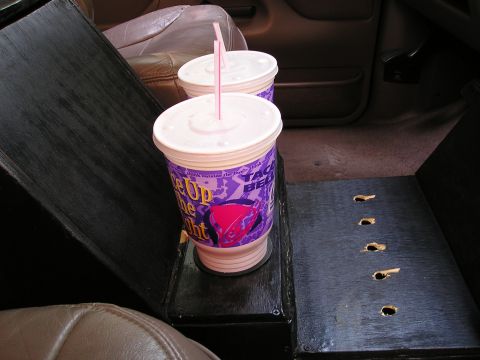 1996 Ford Bronco - Two Taco Bell cups with straws sit in a custom center console inside a vehicle.