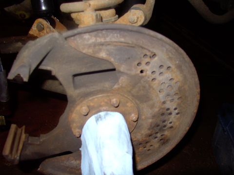 1986 Ford Bronco - Brushed off 19 years of asbestos to reveal a rusty, but pretty solid dust shield. Leave a rag over the spindle shaft.