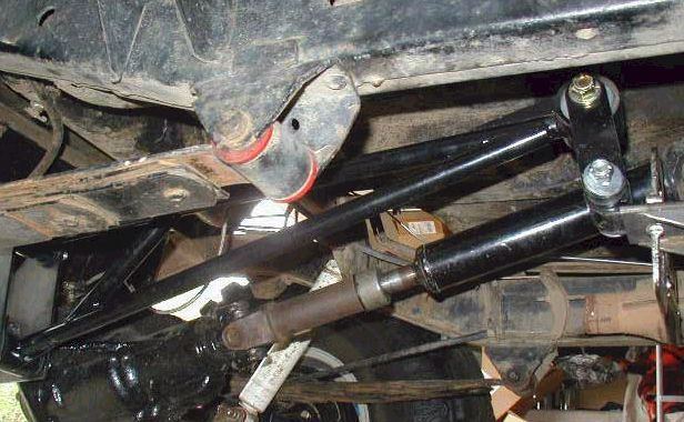 Underbody view of suspension linkage and drive shaft with red bushings