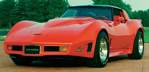 Red Chevrolet Corvette with a hood scoop and "corvette" badge, parked on a paved surface