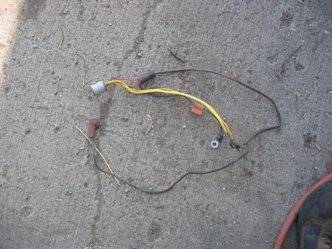 1985 Ford Bronco - A vehicle wiring harness lies on a concrete surface.