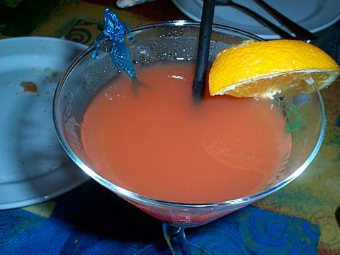 1994 Ford Bronco - A cocktail garnished with an orange slice and a novelty pick sits on a table.