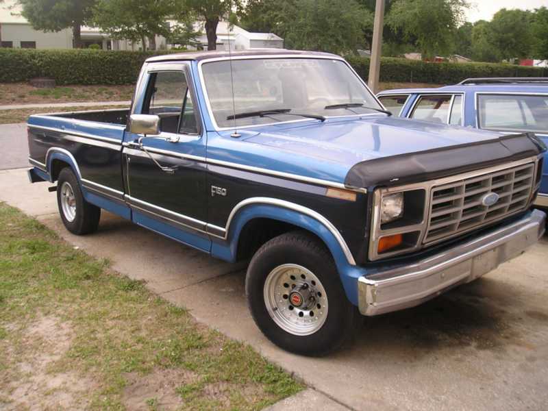 Blue and black 1984 Ford F-150 pickup truck, 3q-front view