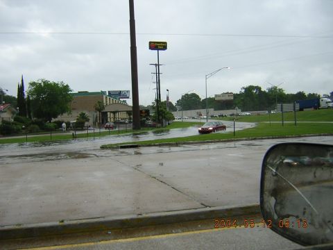 1984 Chevrolet Blazer - Flooded intersection with a red sedan driving through. A Comfort Inn is visible in the background.