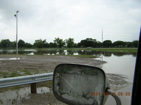 1984 Chevrolet Blazer - A car drives through a flooded area on a cloudy day, as seen from the side mirror of another vehicle.