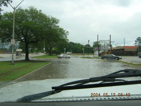 1984 Chevrolet Blazer - Cars navigate a flooded street on a cloudy day, with a sign for JL's Place in the background.