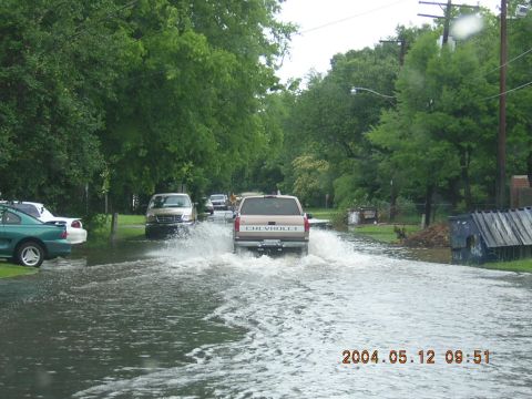 1984 Chevrolet Blazer - A Chevrolet pickup truck drives through a flooded street, creating large splashes.
