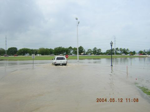 1984 Chevrolet Blazer - A white pickup truck navigates through flooded road conditions under an overcast sky.