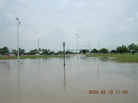1984 Chevrolet Blazer - A flooded parking lot with several cars visible in the distance, under an overcast sky.