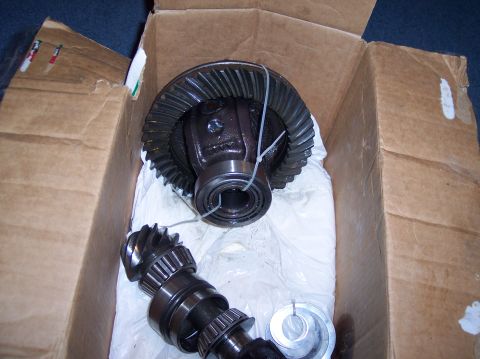 1990 Ford Bronco - A differential gear set and pinion shaft are shown inside a cardboard box, wrapped in protective material.